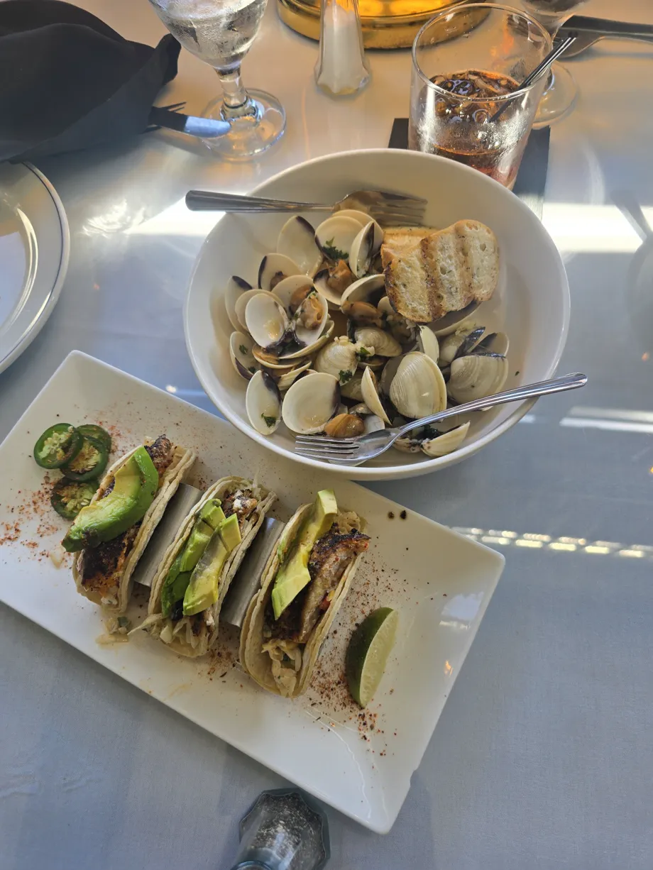 Tacos, clams, and drinks arranged on a Carruthers table